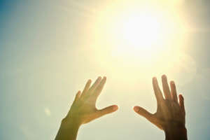 hands reach for light